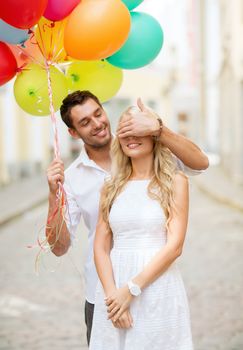 summer holidays, celebration and dating concept - couple with colorful balloons in the city