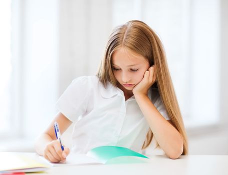 education and school concept - little student girl studying at school