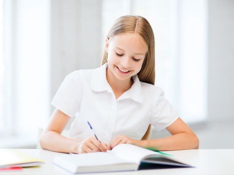 education and school concept - little student girl studying at school