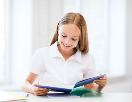 education and school concept - little student girl studying at school