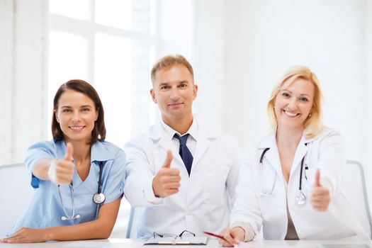 healthcare and medical concept - group of doctors on a meeting showing thumbs up