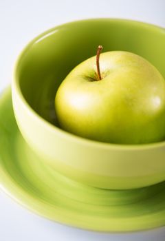 healthy food and cooking concept - green apple in green bowl