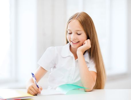 education and school concept - little student girl studying at school