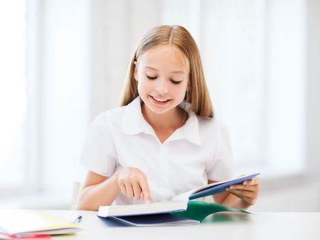 education and school concept - little student girl studying at school