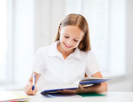 education and school concept - little student girl studying at school