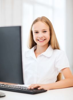 education, school, technology and internet concept - little student girl with computer at school