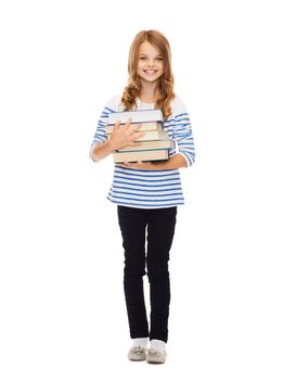 education and school concept - little student girl with many books