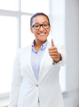 business and education concept - african businesswoman showing thumbs up in office