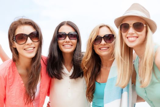 summer holidays, vacation and beach activities - girls in shades having fun on the beach