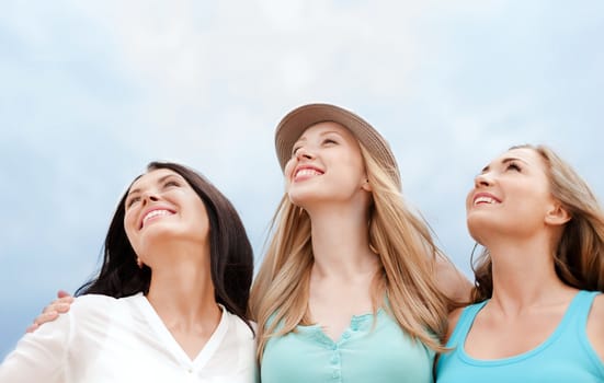 summer holidays and vacation concept - girls looking up in the sky