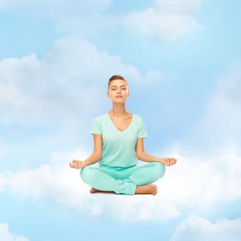 relaxation, meditation and lifestyle concept - girl on the cloud in lotus position and meditating