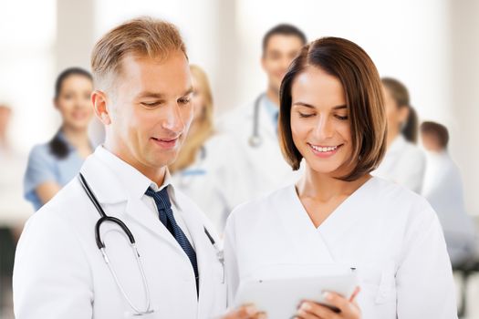 healthcare and technology concept - two doctors looking at tablet pc