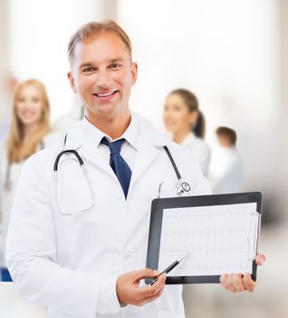 healthcare and medical concept - male doctor with stethoscope showing cardiogram