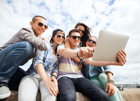 summer holidays, teenage and technology concept - group of teenagers taking picture with tablet pc