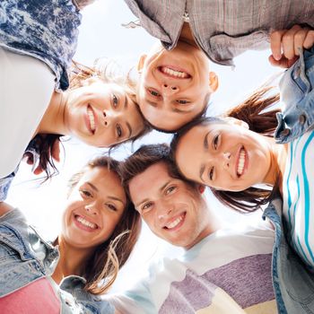 summer holidays and teenage concept - group of teenagers looking down