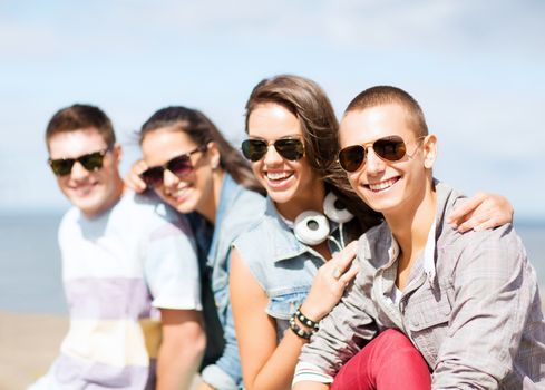 summer holidays and teenage concept - group of teenagers hanging out outside