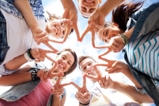 summer holidays and teenage concept - group of teenagers showing finger five gesture