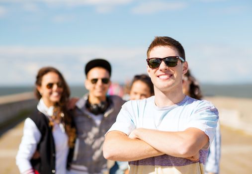 summer holidays and teenage concept - teenager in shades outside with friends