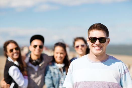 summer holidays and teenage concept - teenager in shades outside with friends