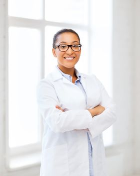 healthcare and medical concept - smiling african female doctor in hospital