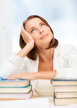 education and business concept - bored young woman with many books indoors