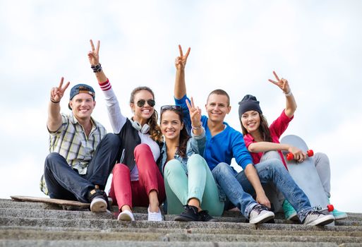 summer holidays and teenage concept - group of teenagers showing finger five gesture