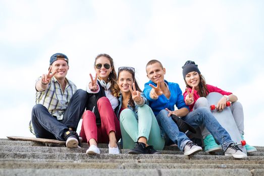 summer holidays and teenage concept - group of teenagers showing finger five gesture