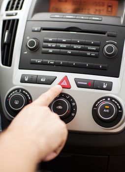 transportation and vehicle concept - man pressing red triangle car hazard warning button