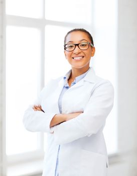healthcare and medical concept - smiling african female doctor in hospital