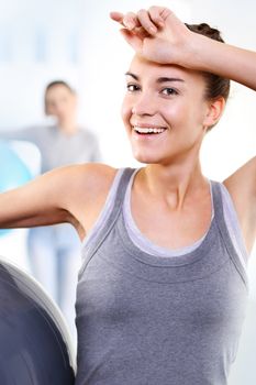 A group of women exercising on a mat with ball