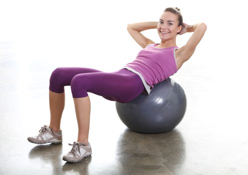 Young woman exercising with large ball training