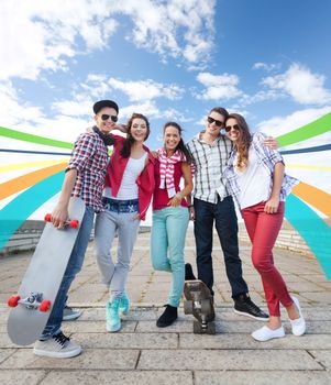 summer holidays and teenage concept - group of teenagers with skates outside