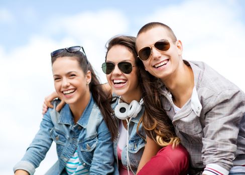 summer holidays and teenage concept - group of teenagers hanging outside