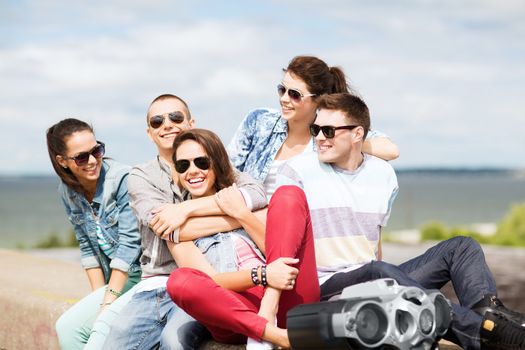 summer holidays and teenage concept - group of teenagers hanging out