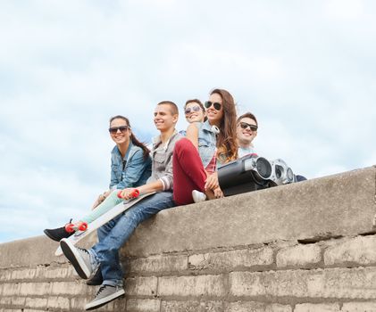 summer holidays and teenage concept - group of teenagers hanging outside