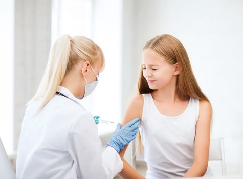 healthcare and medical concept - doctor doing vaccine to child in hospital