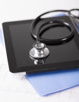 healthcare and technology concept - tablet pc, stethoscope and electrocardiogram