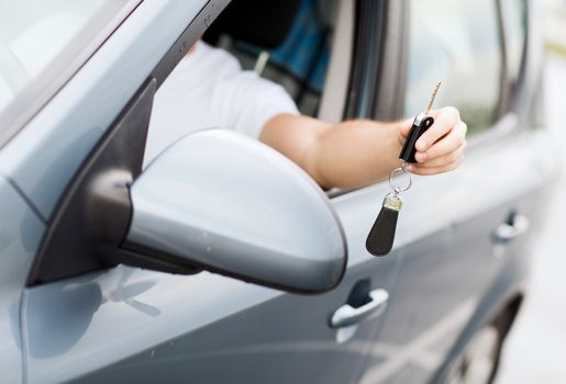 transportation and ownership concept - man with car key outside