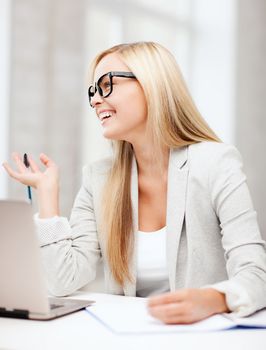 business and education concept - indoor picture of smiling woman with documents and pen