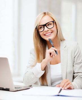 business and education concept - indoor picture of smiling woman with documents and pen