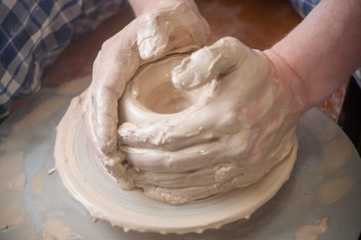 Hands of a potter, creating an earthen jar on the circle