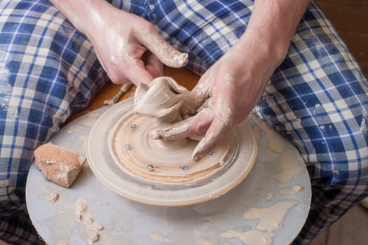 Hands of a potter, creating an earthen jar on the circle