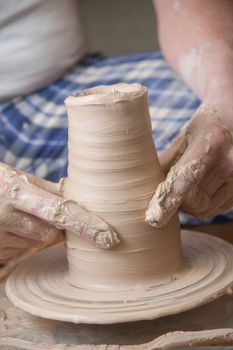 Hands of a potter, creating an earthen jar on the circle