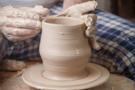 Hands of a potter, creating an earthen jar on the circle