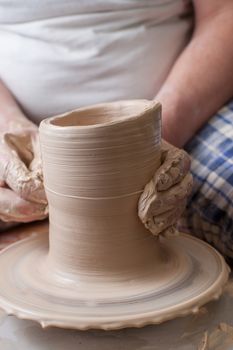 Hands of a potter, creating an earthen jar on the circle