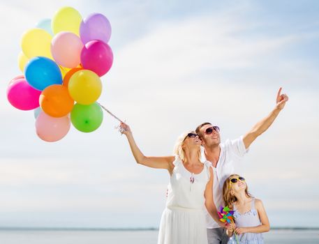 summer holidays, celebration, children and people concept - family with colorful balloons