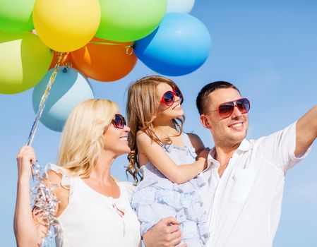 summer holidays, celebration, children and people concept - family with colorful balloons