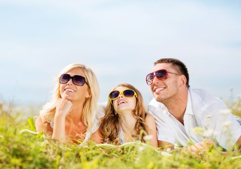 summer holidays, children and people concept - happy family with blue sky and green grass