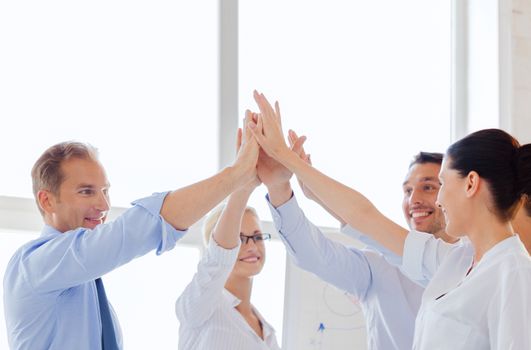 success and winning concept - happy business team giving high five in office