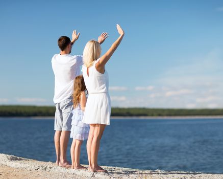 summer holidays, celebration, children and people concept - happy family at the seaside with greeting gesture